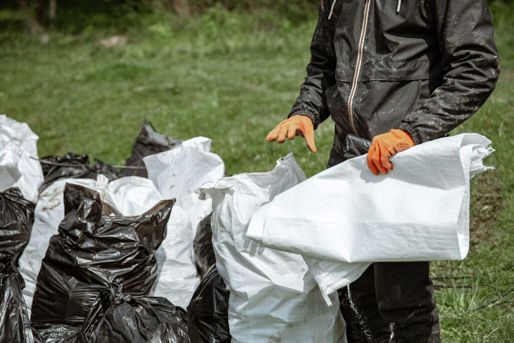 close up of garbage bags in the forest on the grass. close up of garbage bags in the forest on the grass.