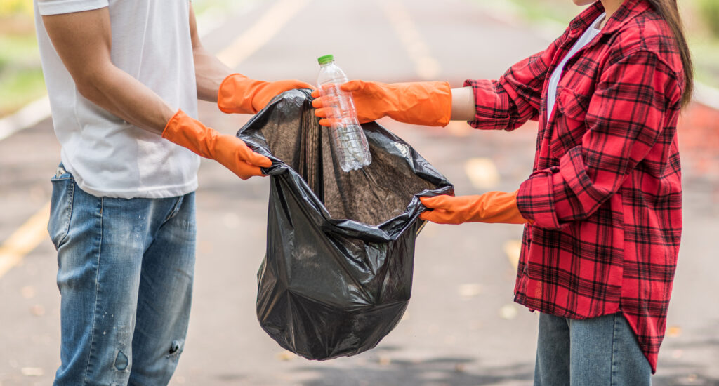 men and women help each other to collect garbage.